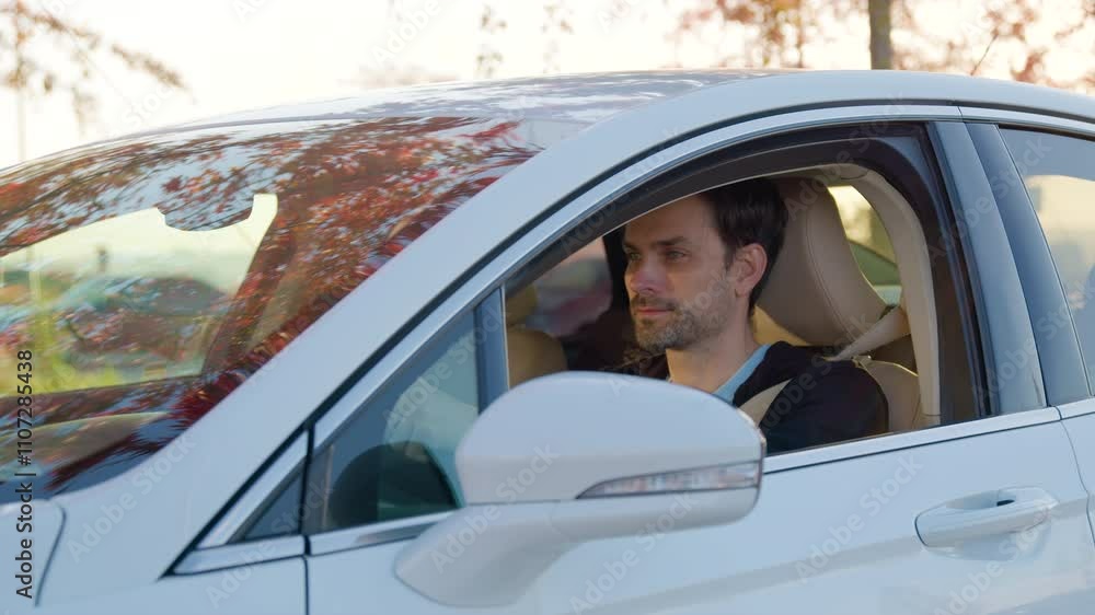 Focused man sits in car-sharing vehicle with opened window Focused man sits in car-sharing vehicle with opened window