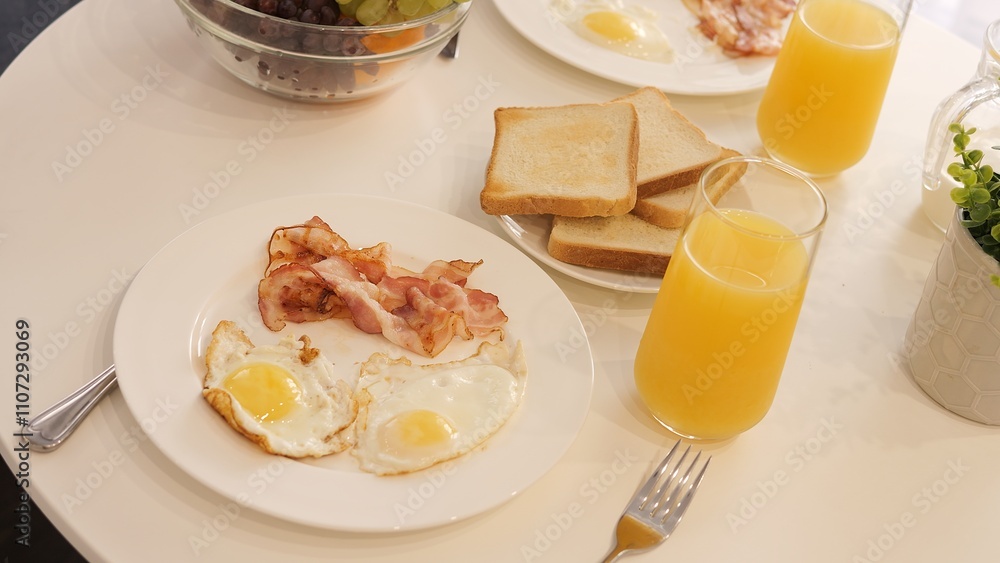 Fototapeta premium Traditional morning breakfast with bacon and eggs is served at table Egg yolks glisten adding an attractive touch to hearty breakfast Perfect combination of bacon and eggs for cozy morning atmosphere