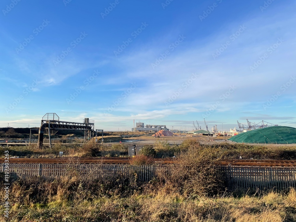 Industrial Landscape with Railway Tracks and Port Infrastructure under Clear Blue Sky Industrial Landscape with Railway Tracks and Port Infrastructure under Clear Blue Sky