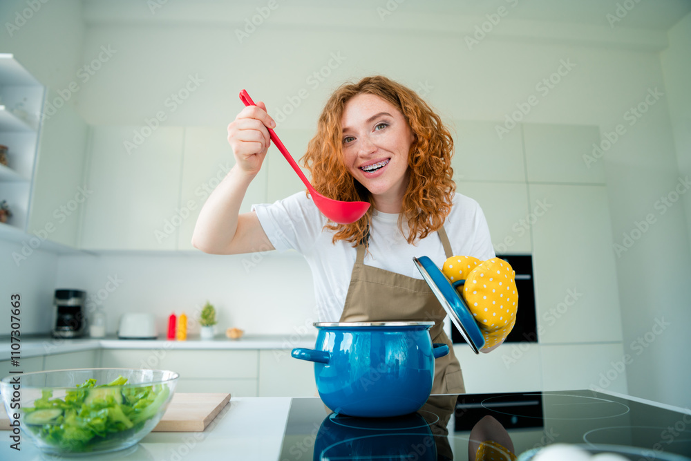 Charming young woman in casual style cooking a homemade meal in a bright kitchen, enjoying the art of preparing a gourmet dish Charming young woman in casual style cooking a homemade meal in a bright kitchen, enjoying the art of preparing a gourmet dish