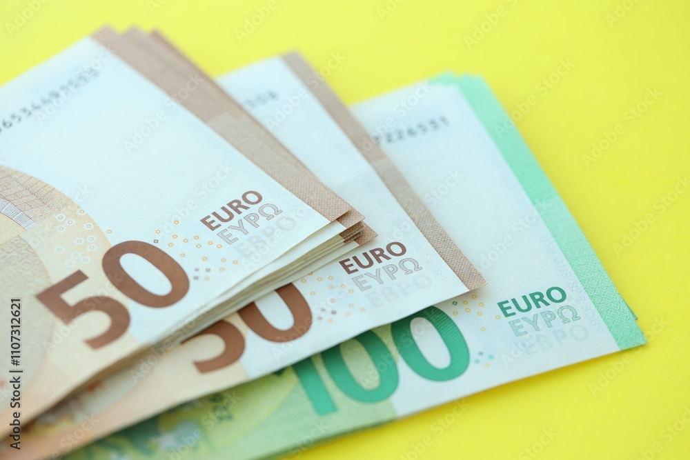 Big amount of one hundred and fifty euro money bills on yellow background Big amount of one hundred and fifty euro money bills on yellow background