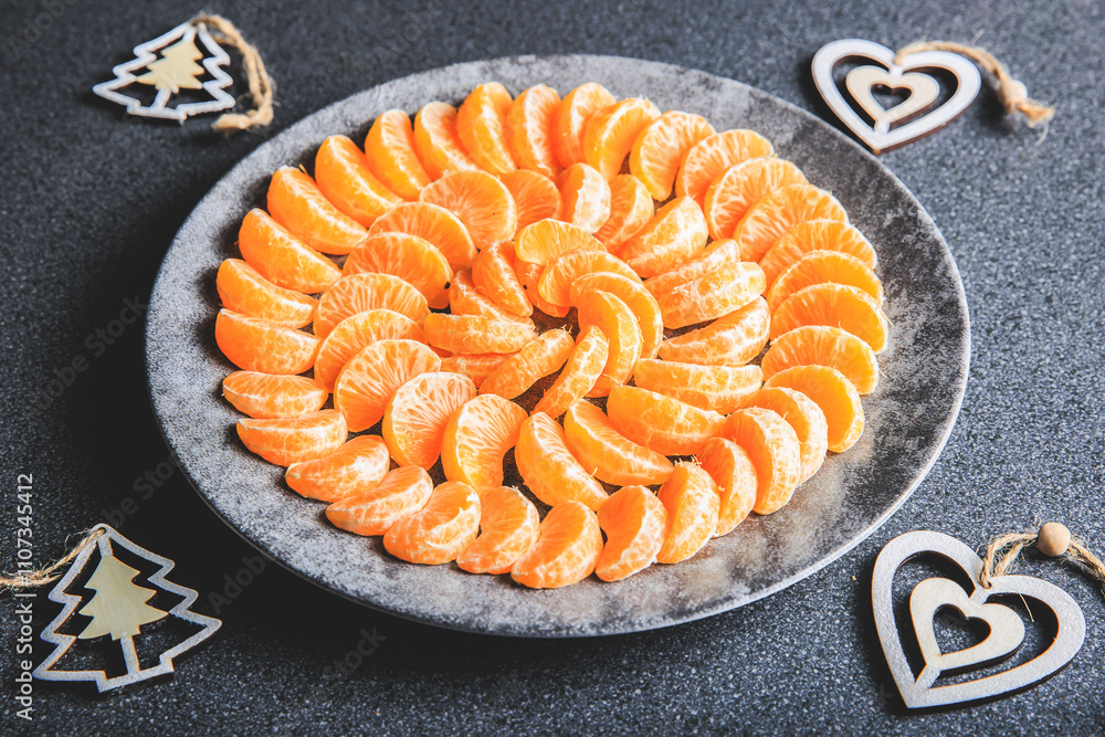 plate of clementine wedges arranged in a circle with christmas decoration