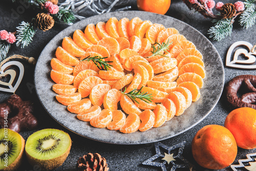Obraz na płótnie plate of clementine wedges arranged in a circle with christmas decoration w salonie