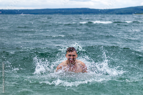 Junger sportlicher aktiver dynamischer Mann im Wasser beim Schwimmen und Fitness Training photo