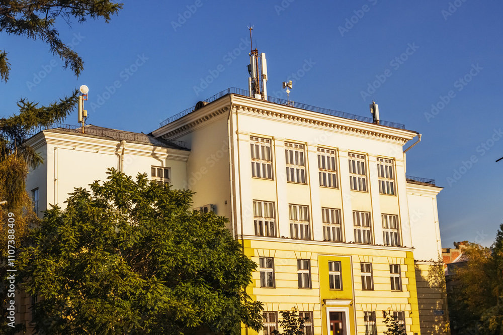 Fototapeta premium An elegant building in Irkutsk with classic architecture and ornate facade illuminated by autumn sunlight. Irkutsk city, historical building.