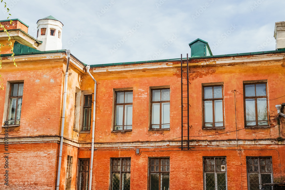 Fototapeta premium Autumn light illuminates the worn facade of a historic building in Irkutsk, showcasing its unique architectural style. Irkutsk city, historical building.