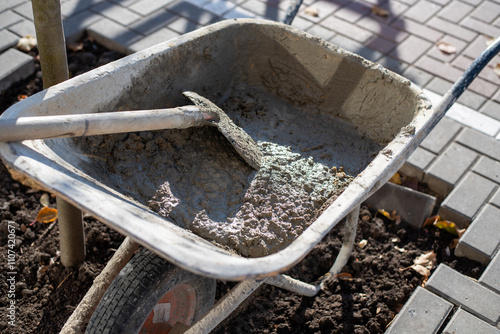 Obraz na płótnie Sidewalk Repair with Wheelbarrow, Concrete, Shovel, and Paving Blocks, Urban Construction Scene w salonie