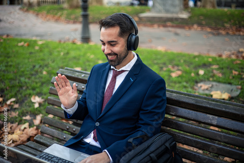 Businessman wearing headphones making video call in park