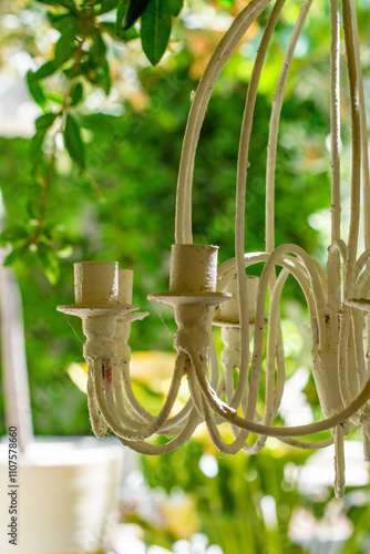 Candelabra, decorative restaurant entrance, White bohemian vibe with abstract objects hanging in the canopy.