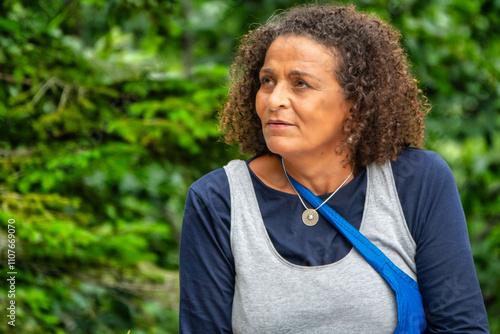 Beautiful South American woman, middle-aged with curly hair, and a lost  gaze
