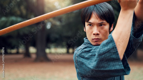 Bokken, Japanese man and outdoor for martial arts in training, exercise and sports as athlete. Male person, culture and ready with bamboo sword, combat and practice for defense technique with bojutsu photo