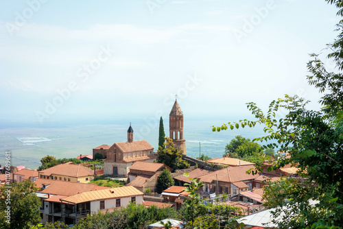 Wallpaper Mural Scenic summer view of Sighnaghi, the 'City of Love' in Georgia, with its charming architecture and vibrant rooftops overlooking the lush Alazani Valley and distant mountains under a clear sky Torontodigital.ca