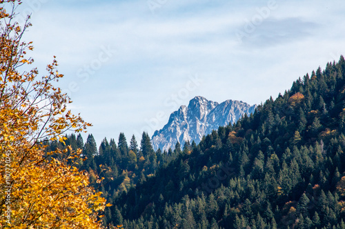 View of the mountains and meadows of the Bavarian Alpine foothills. Forest and mountains in the autumn evening. Blue sky and clouds. photo