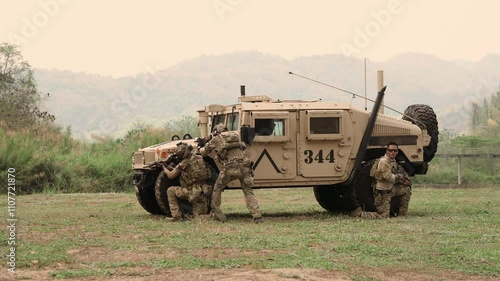 United States Army in camouflage uniforms operation in the forest
with armored vehicle