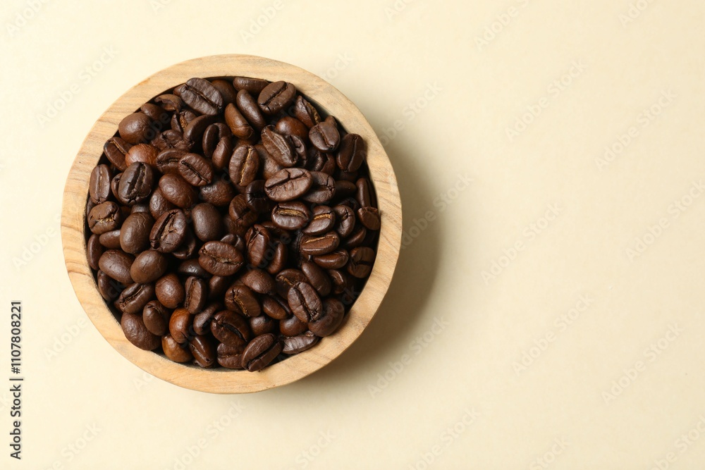 Fototapeta premium Bowl with coffee beans on color background