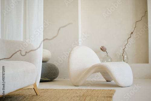 Unordinary white furniture with two oval stones and dried flowers in crystal vase in room of spa center photo