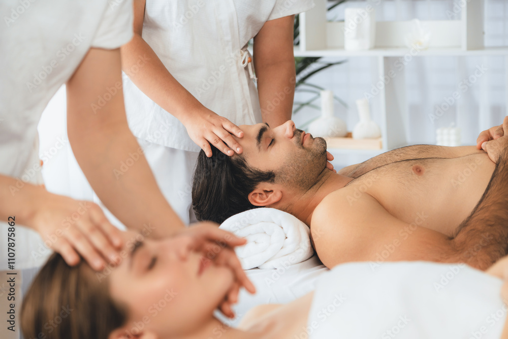 Fototapeta premium Caucasian couple enjoying relaxing anti-stress head massage and pampering facial beauty skin recreation leisure in dayspa modern light ambient at luxury resort or hotel spa salon. Quiescent