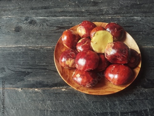 Archidendron pauciflorum or dog fruit in plate on wooden table photo