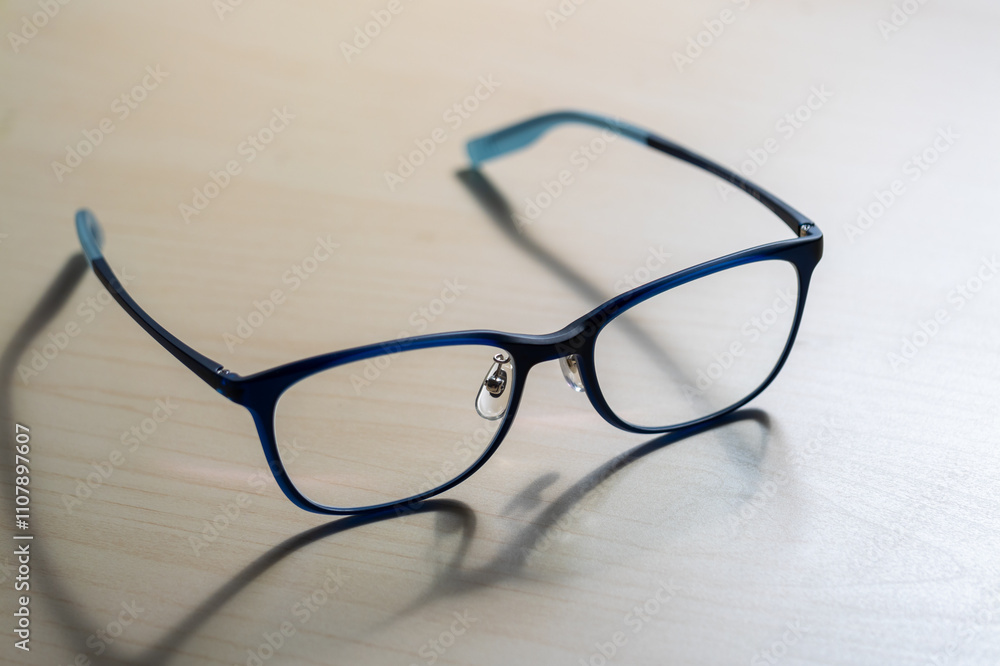 Close-up of stylish eyeglasses on wooden table indoor fashion photography Close-up of stylish eyeglasses on wooden table indoor fashion photography