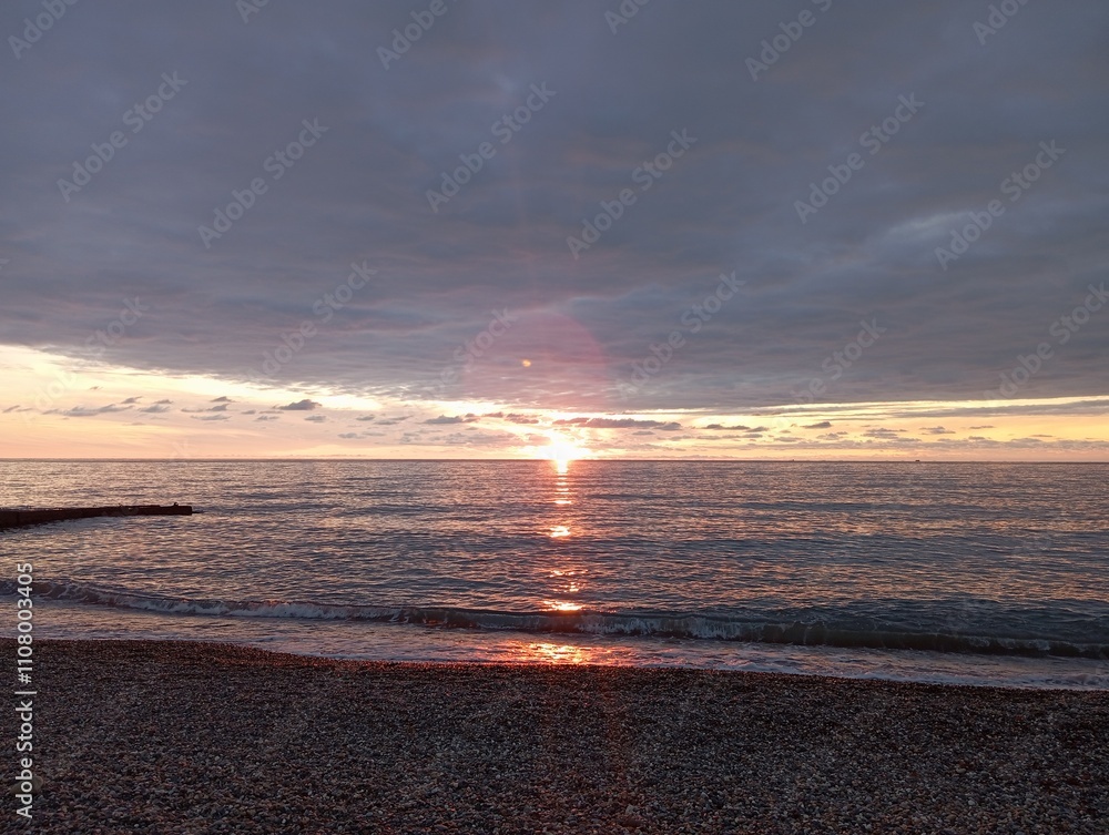 Fototapeta premium sunset on the beach. Red sunset on the sea. The sun is setting over the sea horizon