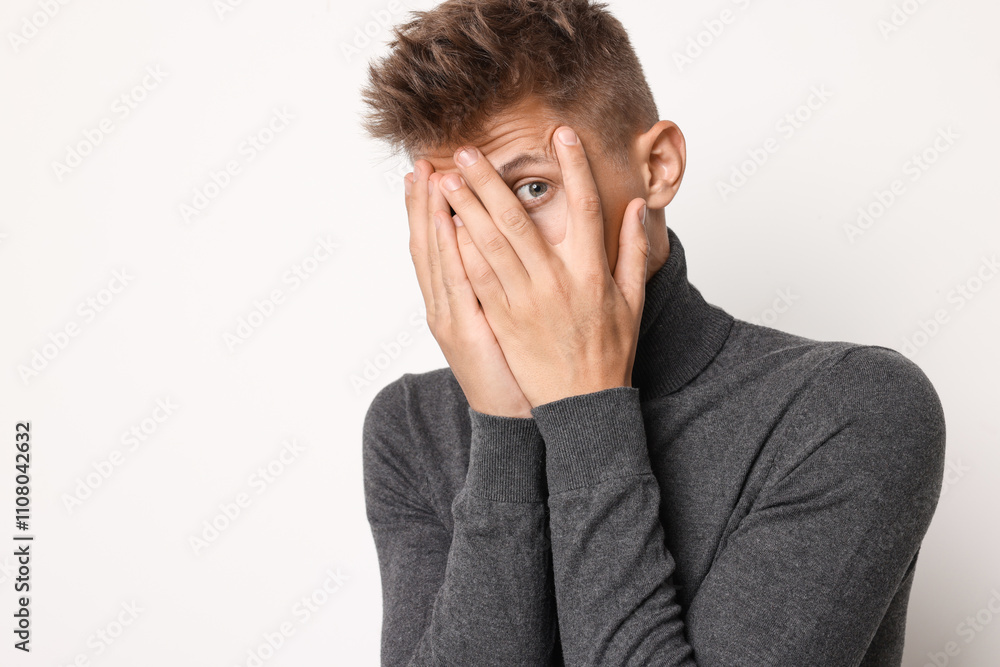Portrait of scared young man on light background, space for text Portrait of scared young man on light background, space for text