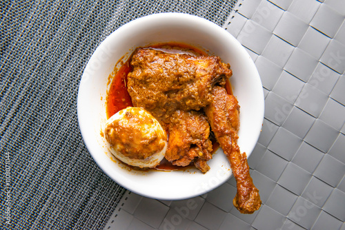 Chicken Jhal Fry with boiled egg served in bowl isolated on grey background top view of bangladeshi food photo