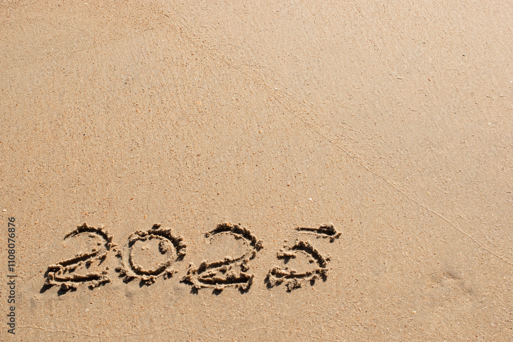 Fototapeta premium Number 2025 written on sand with copy space