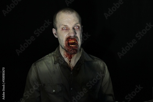 Bloody male zombie in darkness 