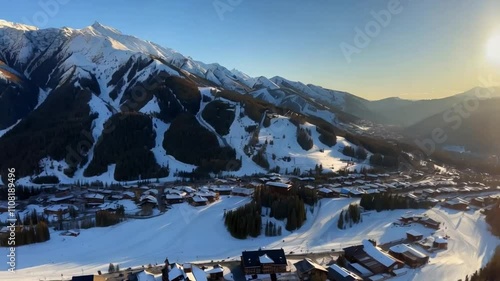 Aerial drone footage captures Vail Village ski resort at sunset, showcasing scenic trails and mountains.