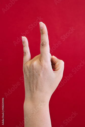 Hand with red background doing rock gesture