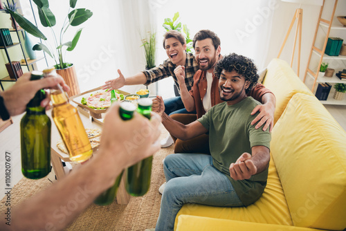 Portrait of group best friends raise fists hold beer gather chill free time modern interior flat indoors