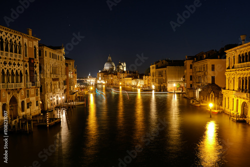 Venice, Italy: Night view of Venice Grand Canal with boats and Santa Maria della Salute church on sunset from Ponte dell'Accademia bridge. Venice, Italy photo