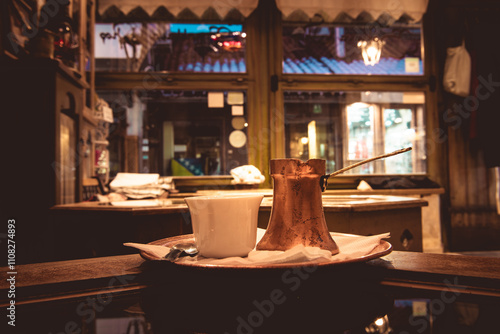 A traditional set of the Bosnian coffee, with a copper teapot known as a cezve and ceramic cup. photo