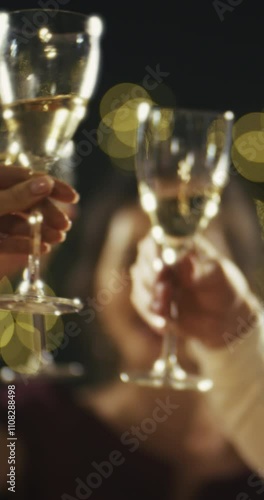 VERTICAL VIDEO: Friends celebrate New Year and Christmas at a party, clink glasses, make toasts, drink champagne, enjoy an evening celebration on Christmas Eve.