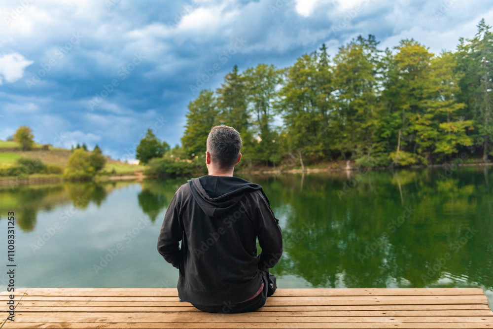 A man sitting on the porch and watching the lake. A man sitting on the porch and watching the lake.