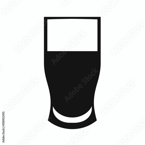 Tall glass with dark liquid resting on a flat surface in a bright setting