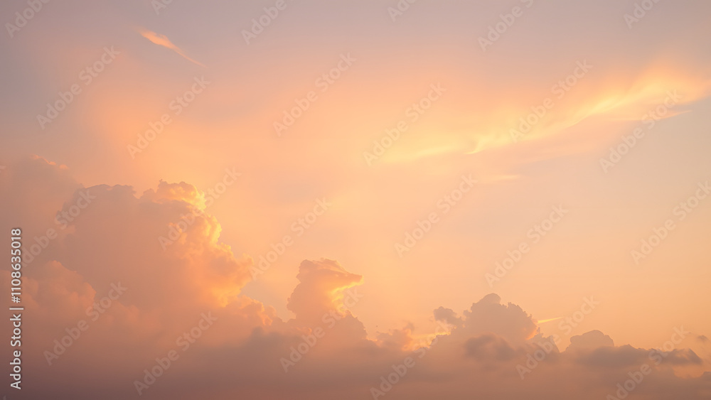 Obraz premium A sunrise background with golden clouds glowing softly against a light pink and blue sky 