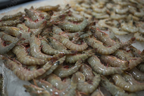 A heap of tiger prawn on ice for sale at a seafood market. Selective focus.