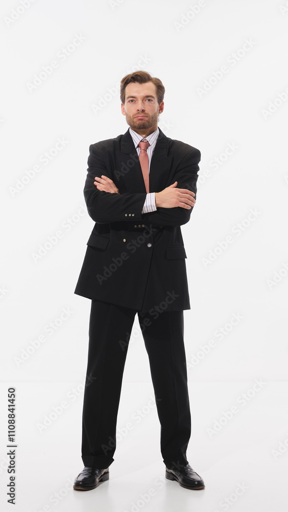 Stylish young man in black suit with red tie, standing confidently with arms crossed against white studio background. Concept of business, leadership, occupation, modern culture. Ad Stylish young man in black suit with red tie, standing confidently with arms crossed against white studio background. Concept of business, leadership, occupation, modern culture. Ad