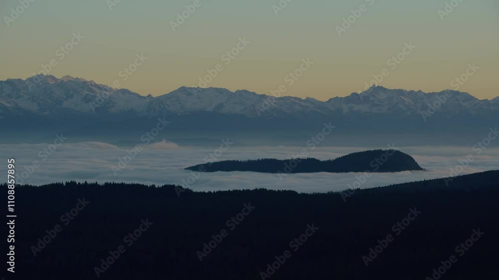 Timelapse of the Belledonne Mountains with a moving Sea of Clouds at Sunset. Featuring a Sea of Clouds Rolling Through the Valleys and Snow-Capped Peaks Illuminated by Golden Light