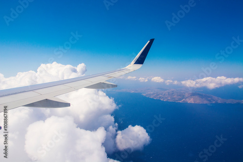 An airplane wing with clear blue sky background flying above Greek islands