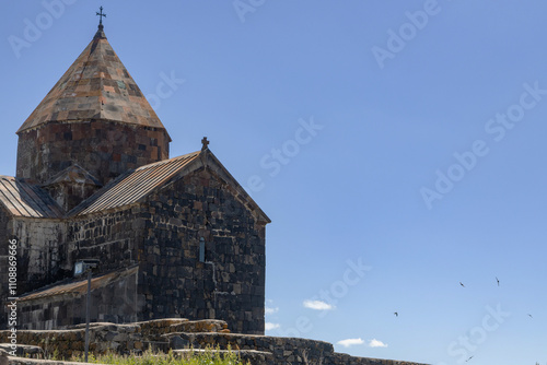 Sevanavank monastery showcases ancient stone architecture under the bright sun amidst Armenias serene landscape. photo