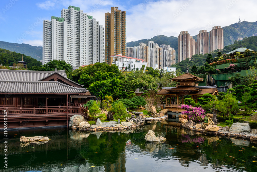 A tranquil pond with koi fish swimming in its clear waters at Nan Lian Garden, Hong Kong. The pond is surrounded by lush greenery and a traditional Chinese style pavilion. A tranquil pond with koi fish swimming in its clear waters at Nan Lian Garden, Hong Kong. The pond is surrounded by lush greenery and a traditional Chinese style pavilion.
