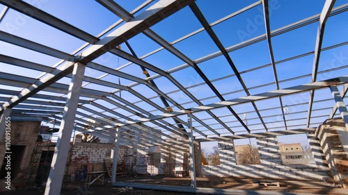 Wallpaper Mural On the top of the building under construction with a frame for future roof. Low angle view at the crane in the backdrop of blue sky. Torontodigital.ca