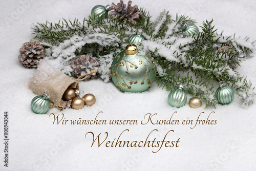 Weihnachtskarte: Weihnachtskugeln und Tannenzweigen im Schnee mit dem Text wir wünschen unseren Kunden ein frohes Weihnachtsfest. photo