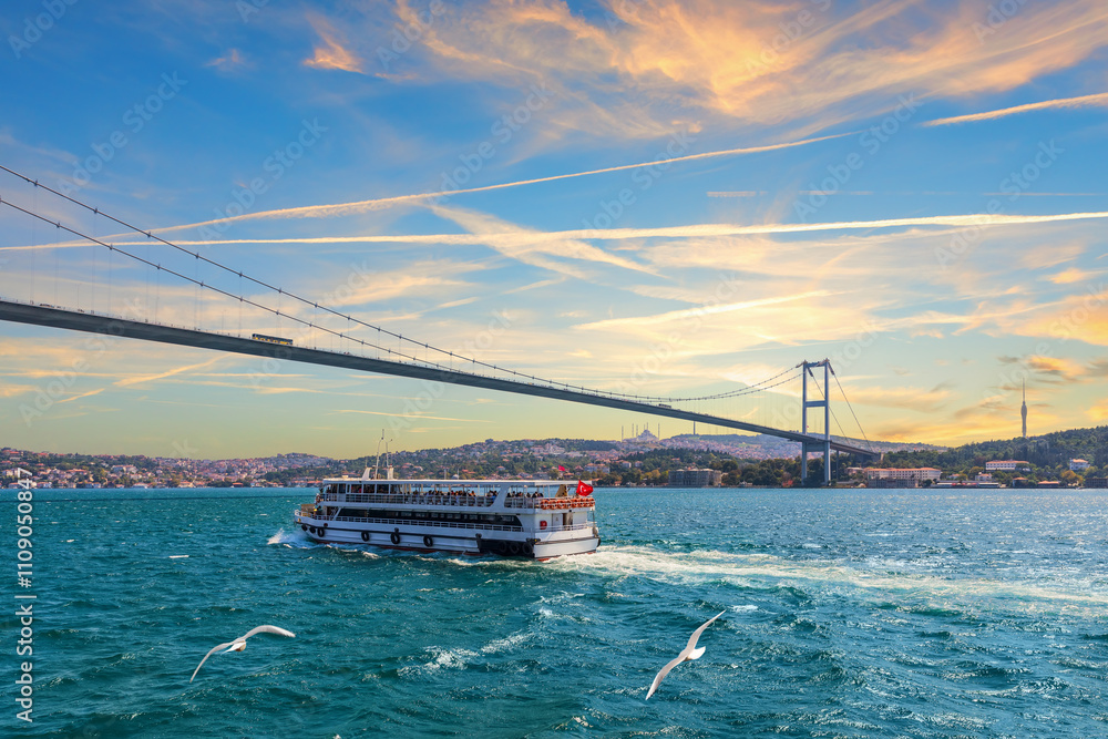 Cruise ship is sailing under the Bosphorus bridge, sunset view, Istanbul, Turkey