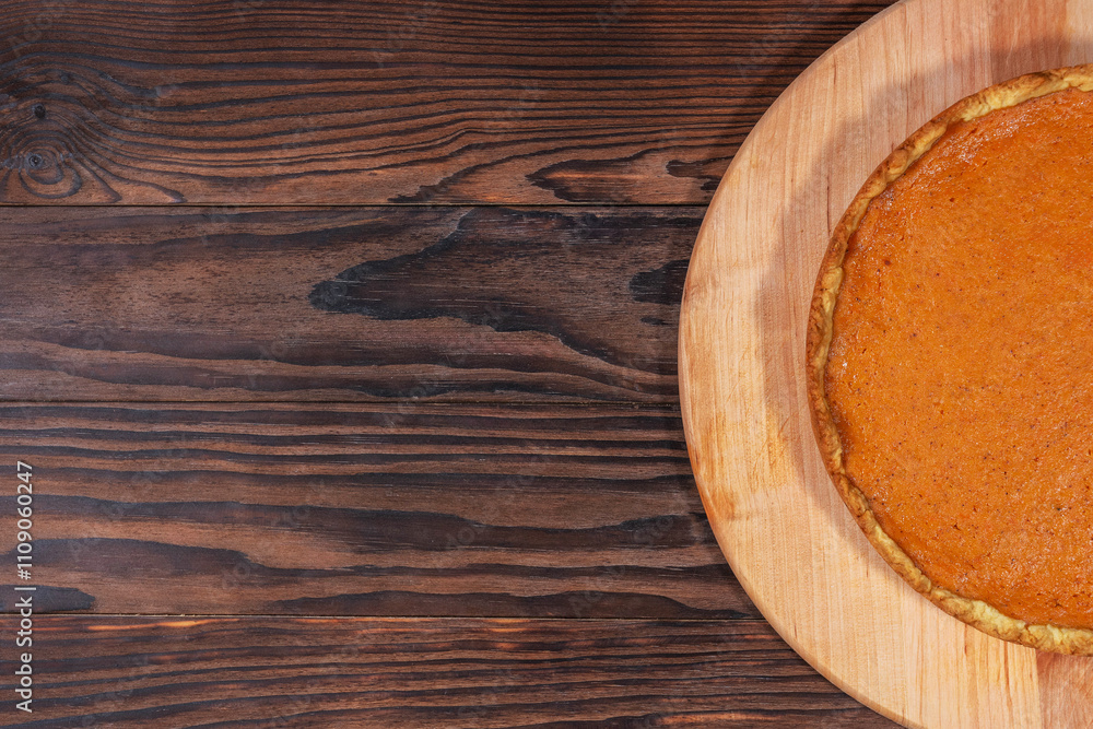 Fototapeta premium Pumpkin Pie on Rustic Wooden Background with Empty Space