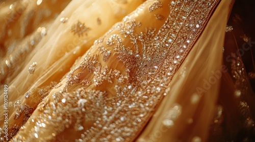 Close-up of a golden Indian wedding dress showcasing intricate zari work, beads, and elegant patterns photo