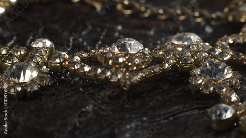 Shiny diamond necklace lying on antique leather book. Rich texture. Macro shot.