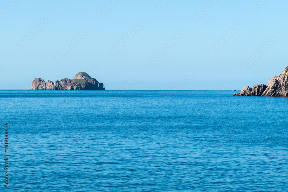 Naklejka premium rock on the calm sea on a sunny day